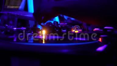DJ台上的乙烯基播放器，派对上<strong>播放音乐</strong>，紫色灯光